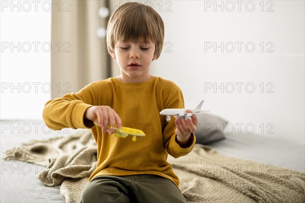 Front view child playing airplane figurines