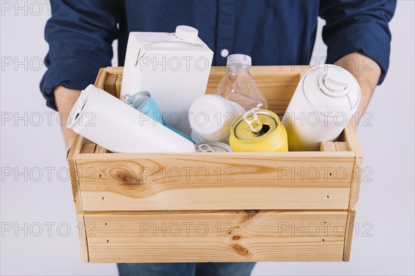 Man s hand wooden box full bottles tin cans