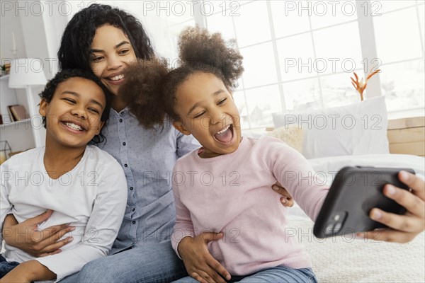 Smiley mother children taking selfie home