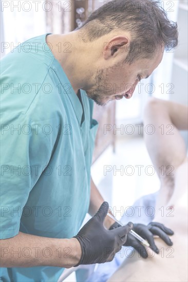 Latin doctor injecting anesthesia to patient on operating table