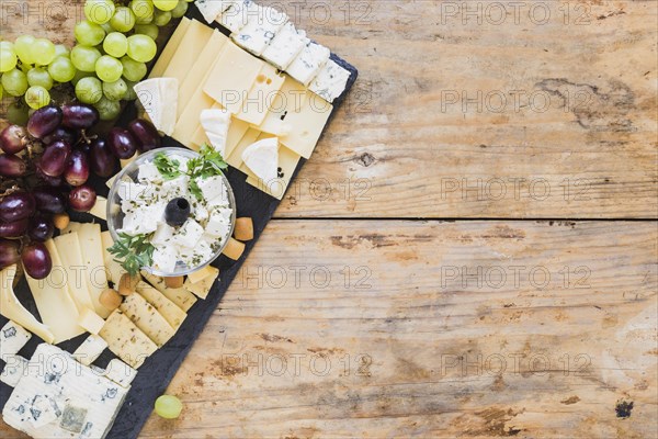 Platter cheese with grapes black slate board table