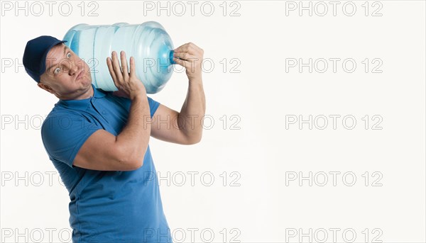 Delivery man carrying heavy water bottle
