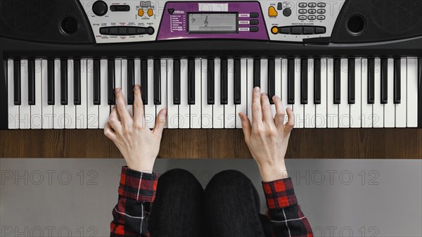 Top view hands playing digital piano