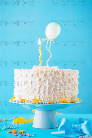 Decorative cake illuminated candle blue backdrop