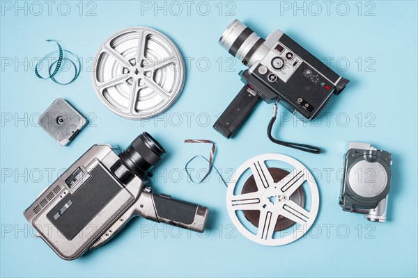 Overhead view film strips film reel various type camcorder blue background