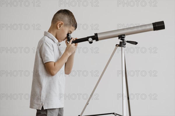 Side view boy using telescope class