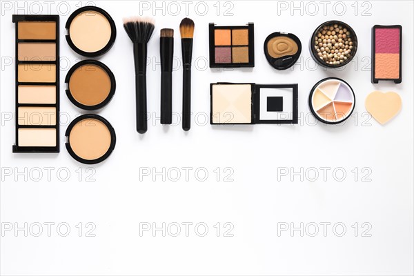 Different facial powders with powder brushes white table