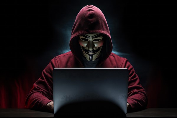 Hacker with Anonymous mask on notebook
