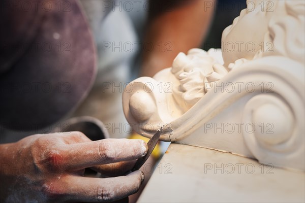 A plasterer restores a stucco figure