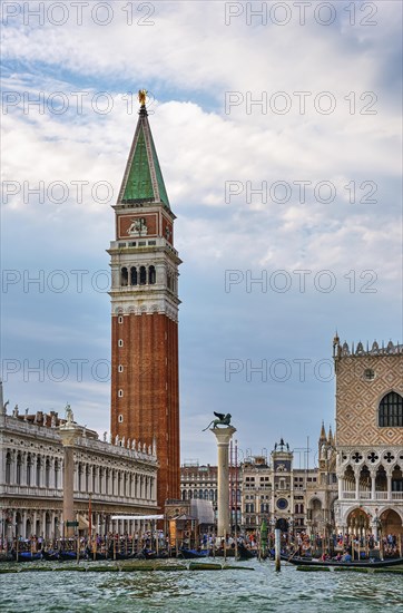 Famous view of St Mark campanile and columns with lion and saint by waterfront of piazzetta of St Mark square on Grand Canal