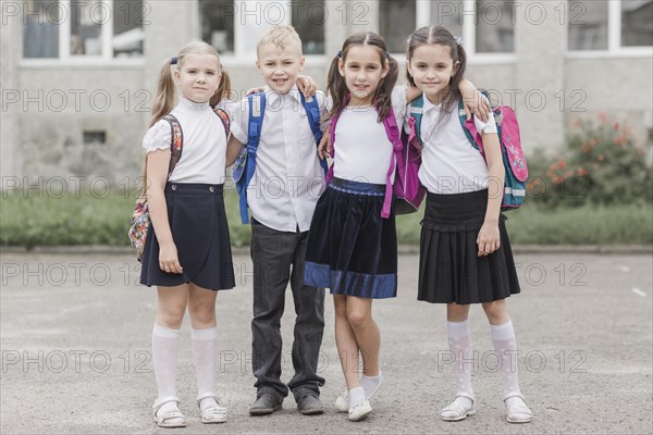 Boy hugging girls near school