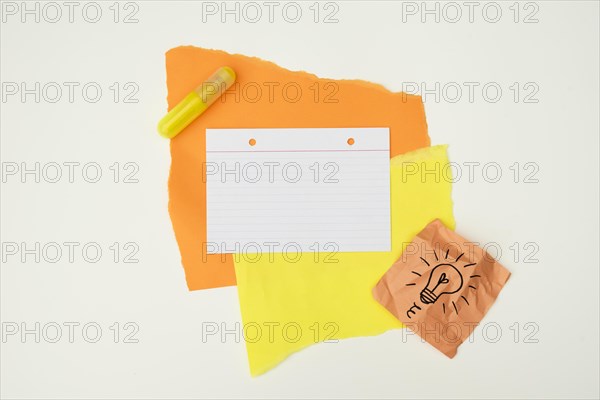 Color paper glue with hand drawn light bulb note paper isolated white background