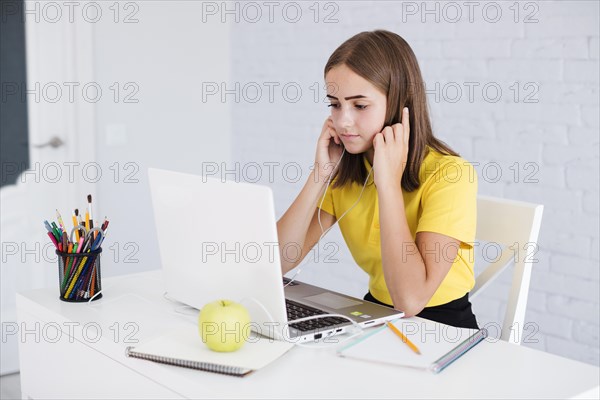 Girl listening music while doing homework