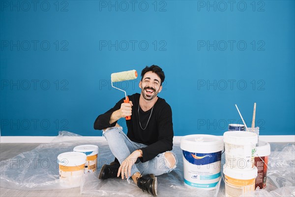 Smiling man showing paint roll