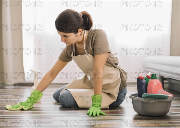 Woman with gloves cleaning floor