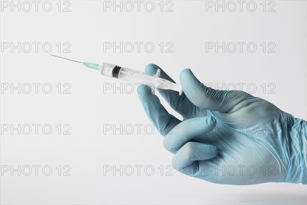Front view doctor with gloves holding syringe