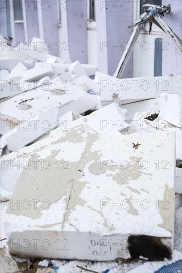 Insulation boards are removed from a facade of a house