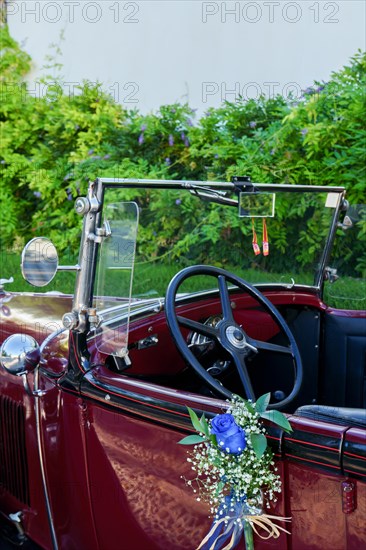 Antique Vintage Wedding Car Decorated with Flowers prepared to take the bride and groom to the church