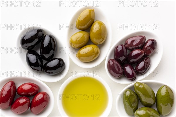 Close up red black yellow purple olives plates with leaves olive saucer