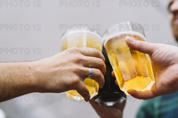 Friend s hand toasting glass beer