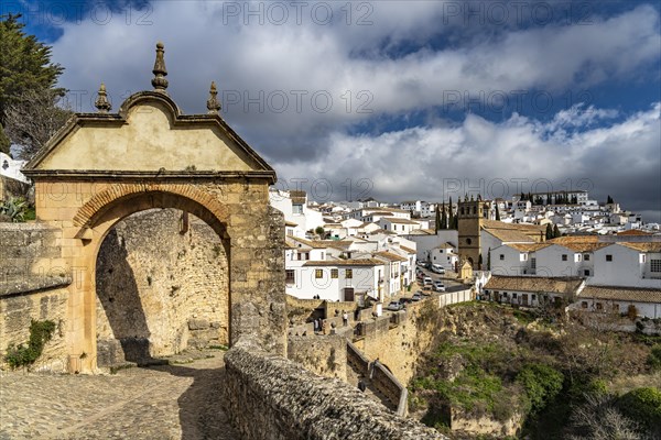 Archway Arco Felipe V and the white houses of the old town with the church Iglesia de Padre Jesus