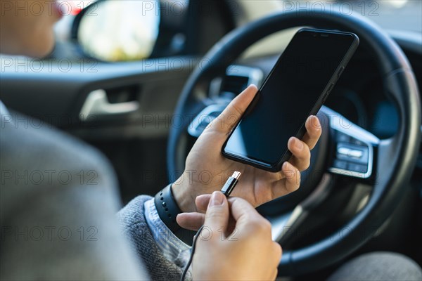 Businesswoman charging her phone car