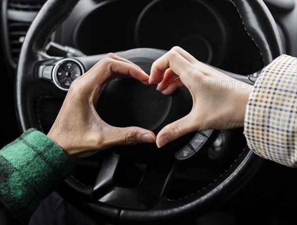 Young couple traveling with car close up doing heart shape
