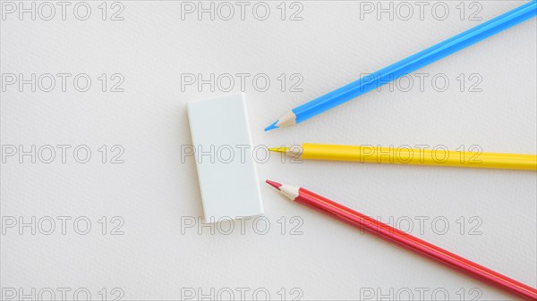 Bright pencils lying near rubber