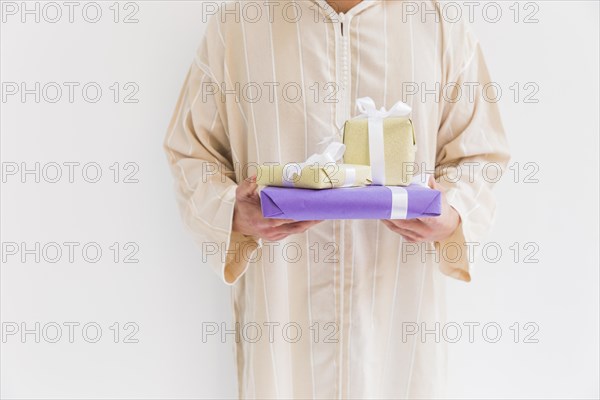 Muslim man holding present boxes
