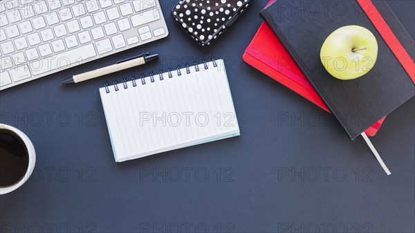 Notepad keyboard near coffee cup apple