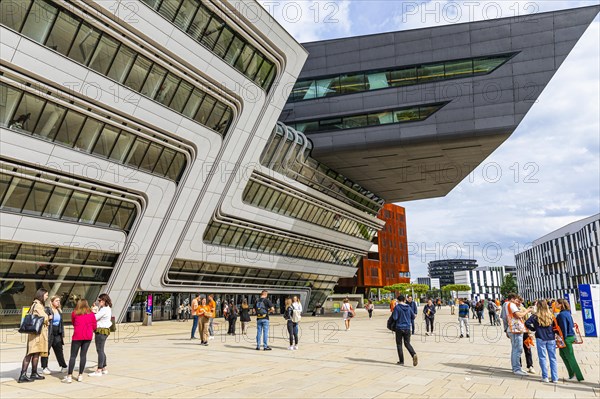 Students in front of modern building on the campus of the University of Economics WU