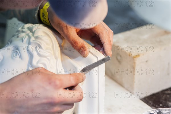 A plasterer restores a stucco figure