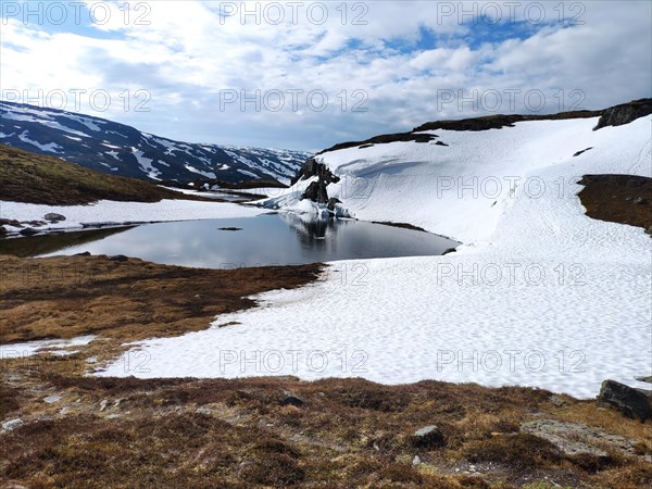 Lake surrounded by snow-capped mountain