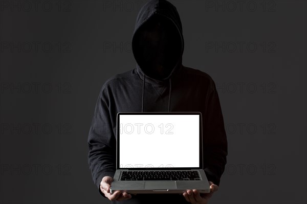 Front view male hacker holding laptop