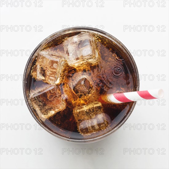 Top view soft drink glass with ice cubes straw