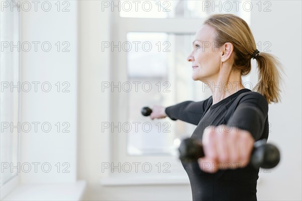 Medium shot female holding dumbbells
