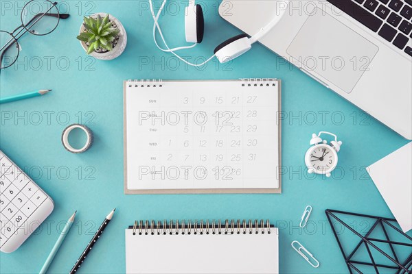 Flat lay desk calendar blue background