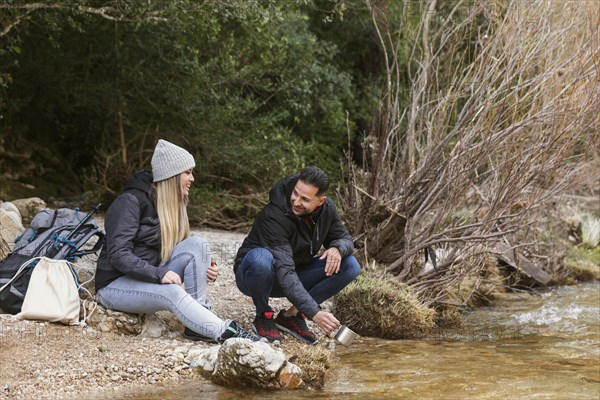 Couple nature drinking water from river