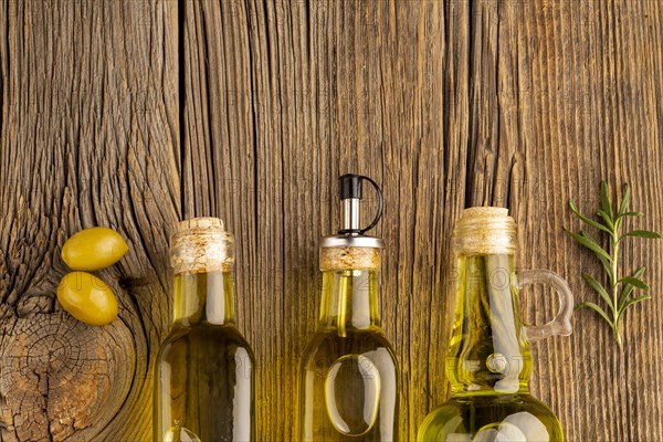 Yellow olives oil bottles wooden background