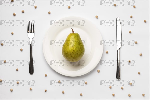 Flat lay fresh pear plate with cutlery