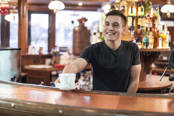 Smiling barista giving coffee