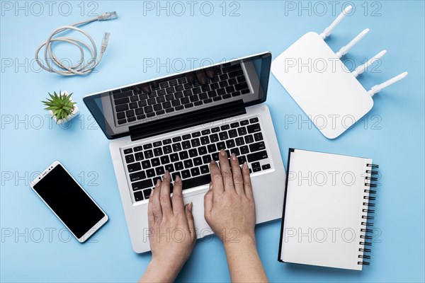 Top view wi fi router with hands using laptop smartphone