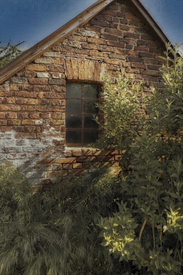 Old brick house with mullioned window in the sunlight