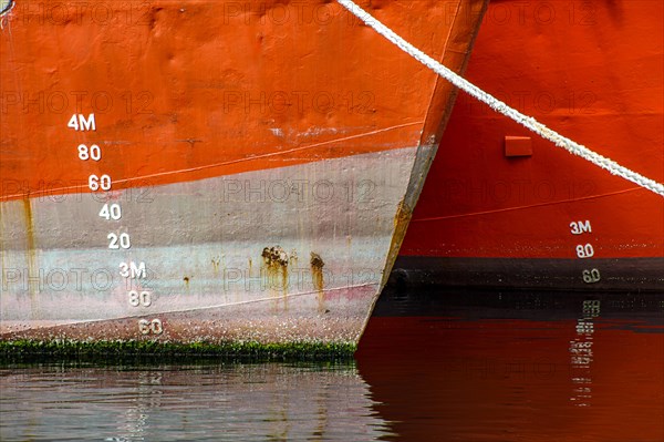 Ship bow showing signs of deterioration with rust and parasites attached to the hull