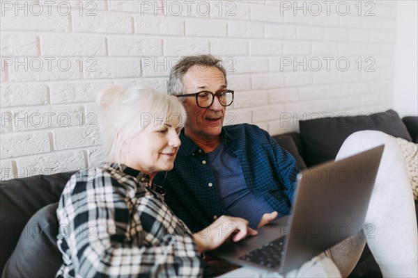 Elderly couple retirement home using laptop