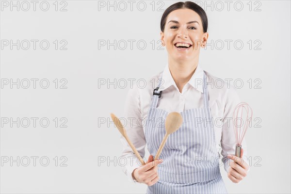 Woman apron smiling holding utensil