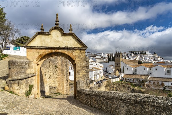 Archway Arco Felipe V and the white houses of the old town with the church Iglesia de Padre Jesus