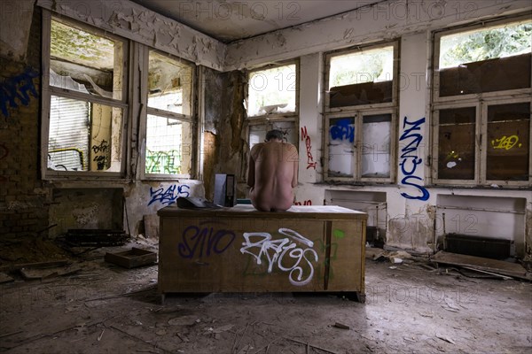 Man dressed in suit wearing VR glasses in a dilapidated office building