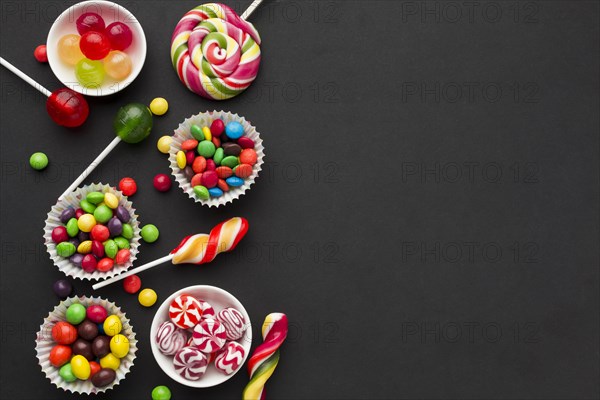 Top view tasty candies black table