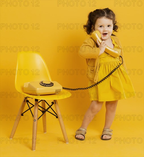 Cute child posing while holding telephone
